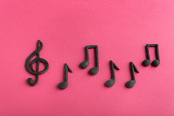 Treble clef and music notes on pink background. Music symbol. Key of G. Violin key. Musical notation.