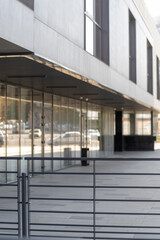 Modern building. Architecture of the 21st century. Metal fence on the background of the facade of the building.