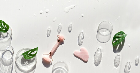 Moisturizer, pink quartz face roller with exotic monstera leaves and orchid flowers and glass...