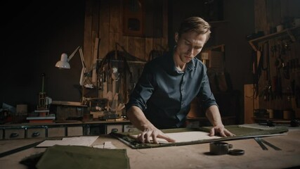 Tailor workshop. Professional man working at workroom with fabric and pattern, preparing to cutting canvas for clothes - Powered by Adobe
