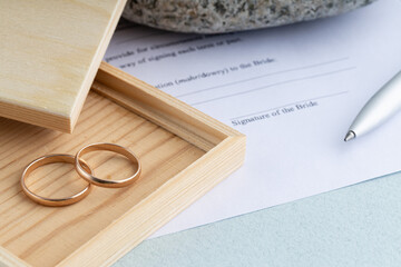 Sign of marriage contract form agreement with a pair of wedding rings