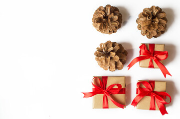 Festive concept - a gift with a bow and bumps on a white background. composition for christmas, new year and holidays. flat lay with place for text.
