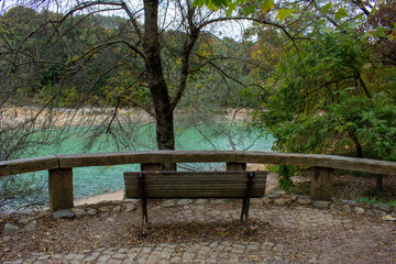 An empty wooden bench by the lake. Calmness, rest, sitting in nature.