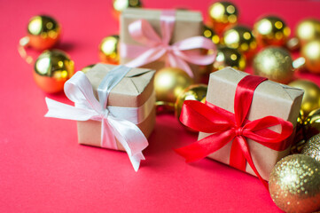 Festive concept - a gift with a bow and Christmas toys on a red background. composition for christmas, new year and holidays. flat lay with place for text.
