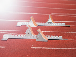 Starting blocks on red running tracks, light reflection an lens flare