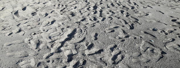 Many footsteps on a sandy beach