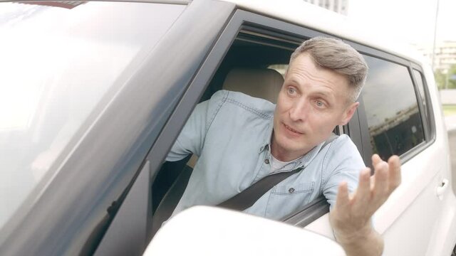 Angry annoyed driver screaming, looking out from car window, obstructed traffic