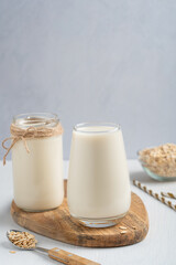 Vegan lactose free homemade oat milk made of oats grain with oatmeal flavor served in drinking...