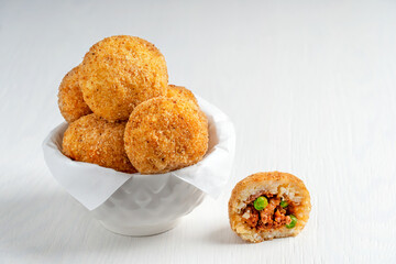 Tasty homemade Arancini Italian or Sicilian rice balls stuffed with minced meat, tomato sauce and...