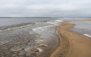 Fototapeta na wymiar Sandy riverbank in winter