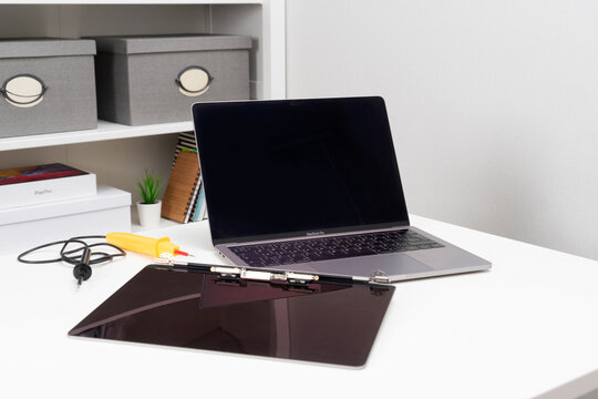 Moscow, Russia, October 3, 2021: A broken monitor and a repaired laptop sit on a table in light white room.