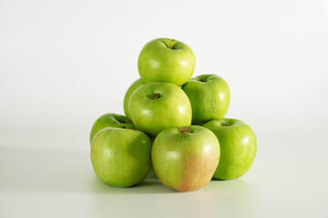 Fototapeta na wymiar A slide of green apples on a white background.