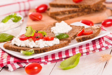Rye bread with cottage cheese, basil and tomato. 