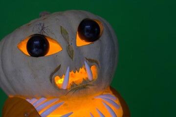alien pumpkin with black eyes and shark teeth with green background detail