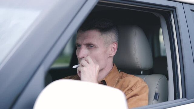Man in his 40s lighting weed joint and smoking in a car, reckless driving, dui