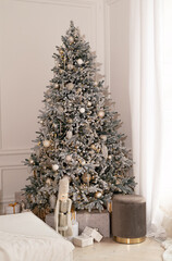 New Year's decor in a photo studio in gray and white colors. A snow-white tree, gifts and lanterns, defocus. Location for a photo shoot. Christmas