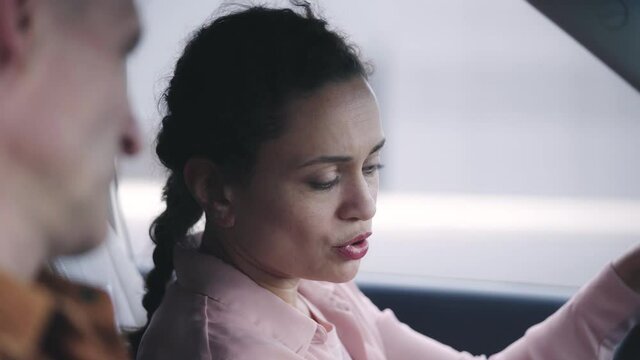 Woman newbie driver passing driving exam, sitting next to instructor in a car