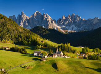 Santa Maddalena. Val di Funes. Dolomite Alps. Italy. The mountains and the forest before sunset. Natural landscape in the summertime. Photo in high resolution..