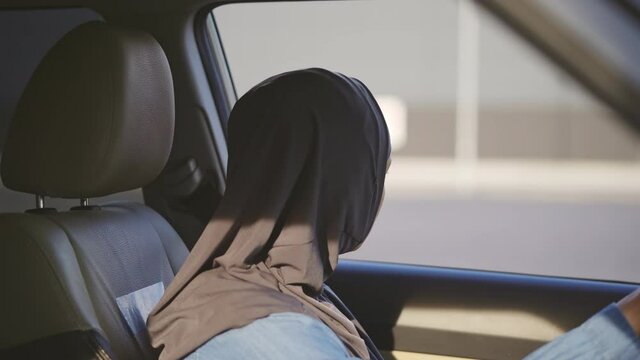 Upset Arab woman looking at road from car window, wants to escape from hard life