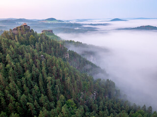 Morning view to misty Swiss Bohemian landscape during sunrise. Morning mist