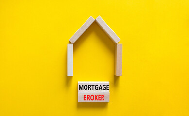 Fototapeta na wymiar Mortgage broker symbol. Concept words 'Mortgage broker' on wooden blocks near miniature wooden house. Beautiful yellow background. Business, mortgage broker concept.