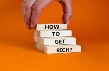 How to get rich symbol. Wooden bloks with words 'How to get rich'. Businessman hand. Beautiful...