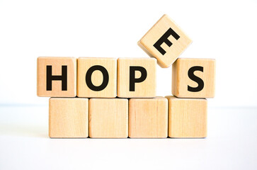 Hopes symbol. The concept word 'hopes' on wooden cubes. Beautiful white table, white background, copy space. Business, psychological and hope and hopes concept.