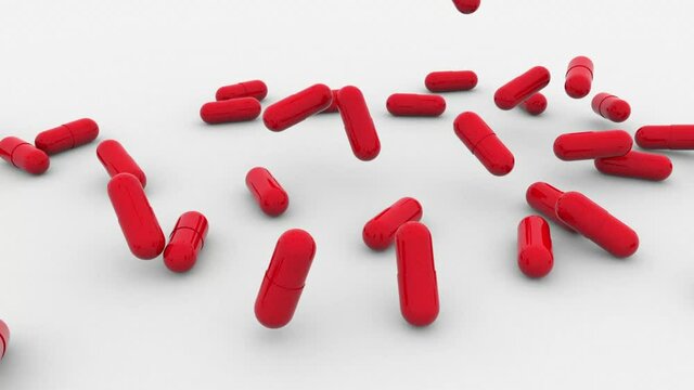 The tablets in hard, shiny red gelatin capsules fall onto a white surface, bounce off on impact, turn over and stop. Cure for the Paxlovid coronavirus.