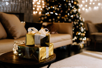 Christmas gifts on the background of the Christmas tree in the evening.