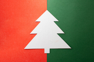 White cardboard Christmas tree on a two-color background. Homemade Christmas tree on a red-green background.