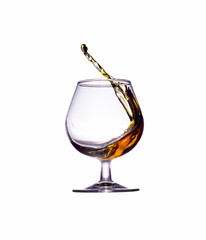 A splash of brandy in a glass glass isolated on a white background.