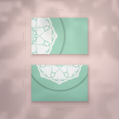 Business card in mint color with Indian white ornaments for your business.