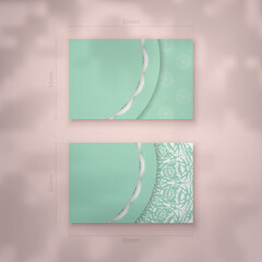 Business card template in mint color with an abstract white pattern for your contacts.