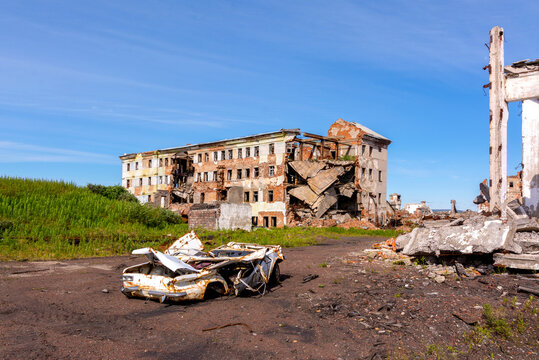The territory of the abandoned mine. Ruined buildings and a wrecked car. Settlement Khalmer-yu, Russia
