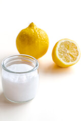 Cosmetic product for skin care. In the foreground is a glass jar with cream. There are lemons in the background. Space for text. Concept: cosmetology, spa, healthy nutrition, medicine, vitamins.