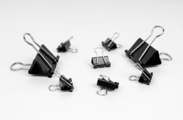 Black clips of different sizes are on a white background.