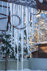 Large transparent icicle on the roof of a house in the village