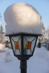 Vintage outdoor lantern in the garden in winter under the snow.