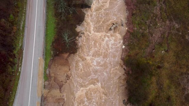 Powerful river. Water flood on river after heavy rain. Swollen river in autumn. Muddy and dirty water flows. Raging river in nature.