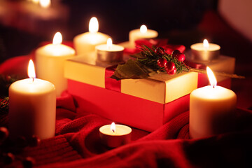 Winter Christmas holidays background with candles, christmas light, toy near a window