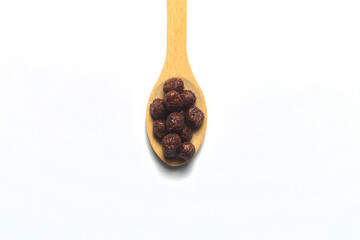 Breakfast cereals in wooden spoon. Healthy muesli with oat flakes, nuts and raisins isolated on white background