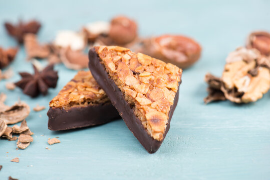 Nut corner, traditional german sweets called Nussecke, covered with chocolate, christmas baking, blue textured background
