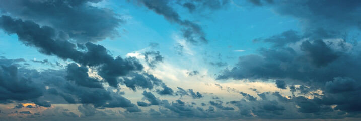 Formless dark clouds blown by the strong wind at evening. Scenic dramatic cloudscape at blue hour....