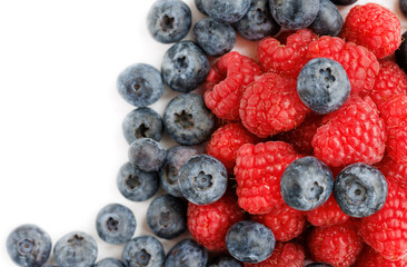Fresh fruits blueberries and raspberries on a white background close-up copy space.