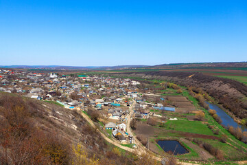 View of the village from the hill . Rustic settlement . Countryside riverside aerial panorama