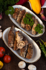 Pork rolls with mushrooms, meat rolls surrounded by greenery and vegetables. Ukrainian dishes is called krucheniki