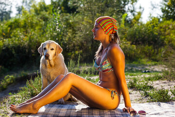 A woman in a bikini by the sunset laying on the beach