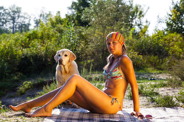 A woman in a bikini by the sunset laying on the beach