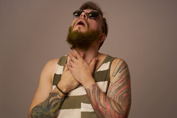 bearded man in striped t-shirt with tattoos posing studio