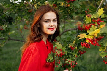 Naklejka premium cheerful woman eating berries outdoors fresh air